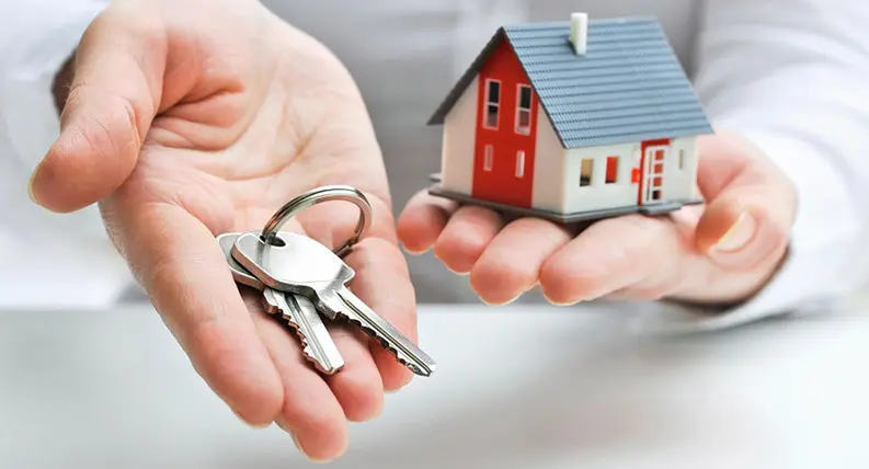 A person holding out their hands with keys in front of them.