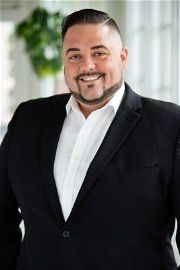 A man in a suit and tie smiling for the camera.