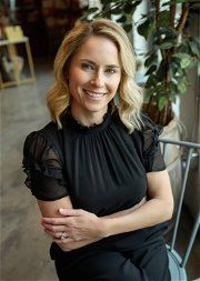 A woman in black shirt smiling for the camera.