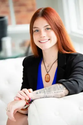 A woman sitting on top of a white couch.